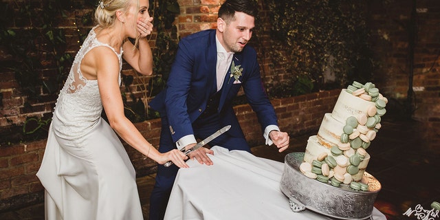 The couple had just started cutting the cake when the table tipped — and the cake went down with it.