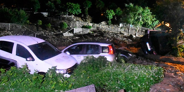 Capsized cars as seen the roads of after they were hit by a landslide in Casargo, near the Italian town of Lecco, in the early hours of Wednesday, Aug. 7.