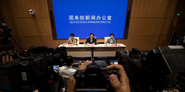 Yang Guang, center, spokesman for the Chinese Cabinet's Hong Kong and Macao Affairs Office, speaks during a press conference in Beijing, Tuesday, Aug. 6, 2019.