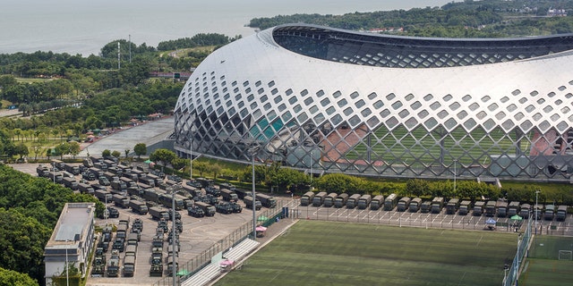 Military vehicles are parked on the grounds of the Shenzhen Bay Sports Center in Shenzhen, China August 15.