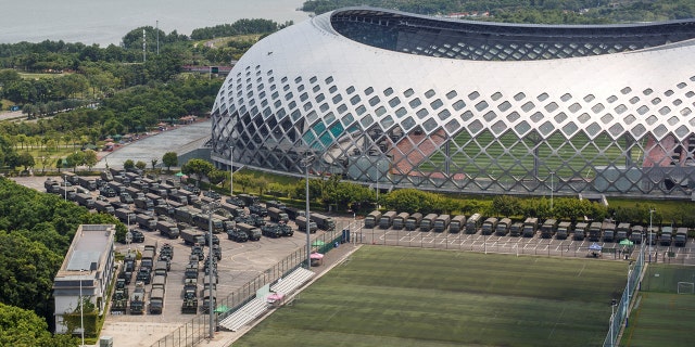 Military vehicles are parked on the grounds of the Shenzhen Bay Sports Center in Shenzhen, China August 15.