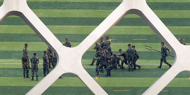 Chinese soldiers practice on the grounds of the Shenzhen Bay Sports Center in Shenzhen across the bay from Hong Kong