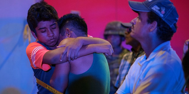 A man is comforted at a crime scene following a deadly attack at a bar by unknown assailants in Coatzacoalcos, Mexico, on Wednesday.