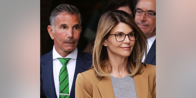 FILE - In this April 3, 2019, file photo, actress Lori Loughlin, front, and husband, clothing designer Mossimo Giannulli, left, leave federal court in Boston after facing charges in a nationwide college admissions bribery scandal.