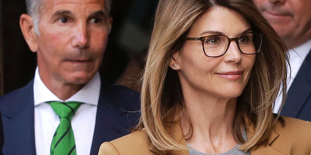 In this April 3, 2019, file photo, actress Lori Loughlin, front, and husband, clothing designer Mossimo Giannulli, left, leave federal court in Boston after facing charges in a nationwide college admissions bribery scandal. 