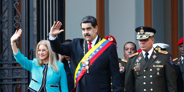 Venezuela's President Nicolas Maduro, center, and first lady Cilia Flores, wave to supporters as they leave the National Pantheon after attending a ceremony to commemorate an 1800's independence battle, in Caracas, Venezuela, Wednesday, Aug. 7, 2019. 