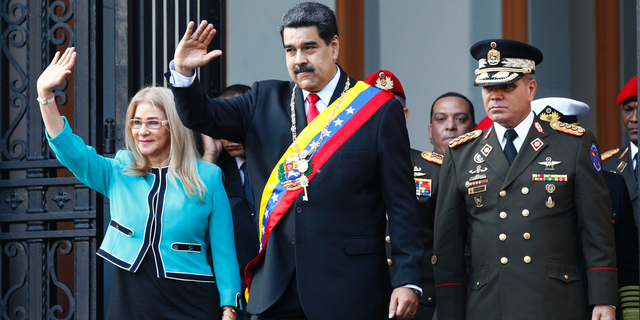 Venezuela's President Nicolas Maduro, center, and first lady Cilia Flores, wave to supporters as they leave the National Pantheon after attending a ceremony to commemorate an 1800's independence battle, in Caracas, Venezuela, Wednesday, Aug. 7, 2019. 