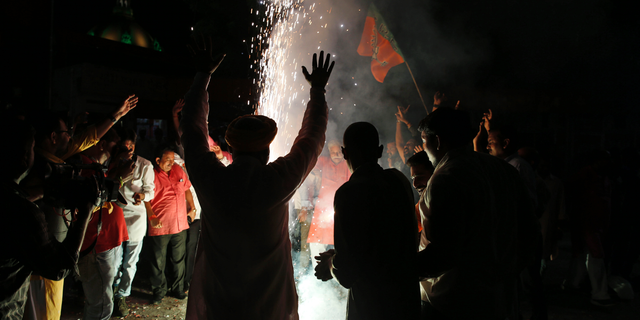 Supporters of India's ruling Bharatiya Janata Party (BJP) light firecrackers and celebrate the government revoking Kashmir's special status, in Lucknow, India, Tuesday, Aug. 6, 2019. Indian lawmakers passed a bill Tuesday that strips the statehood from the Indian-administered portion of Muslim-majority Kashmir amid an indefinite security lockdown in the disputed Himalayan territory, actions that neighboring Pakistan warned could lead to war.