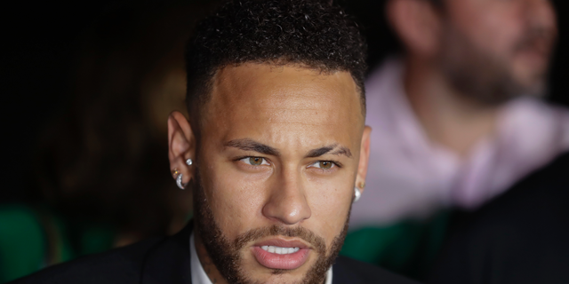 In this June 13, 2019 photo, Brazilian footballer Neymar speaks to the press as he leaves a police station.