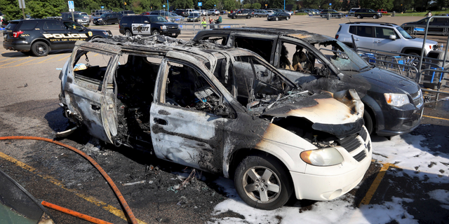 This Tuesday, Aug. 6, 2019 photo shows two charred vehicles in the parking lot of a Walmart in Fridley, Minn. (David Joles/Star Tribune via AP)