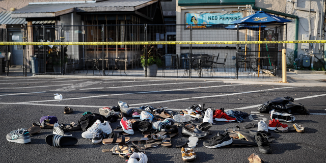 Shoes are piled outside the scene of a mass shooting including Ned Peppers bar, Sunday, Aug. 4, 2019, in Dayton, Ohio.