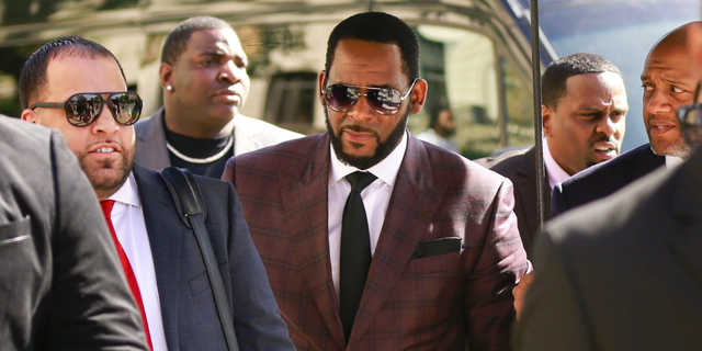 R. Kelly, center, arrives at the Leighton Criminal Court building for an arraignment on sex-related felonies in Chicago onÂ June 26, 2019. (AP Photo/Amr Alfiky, File)