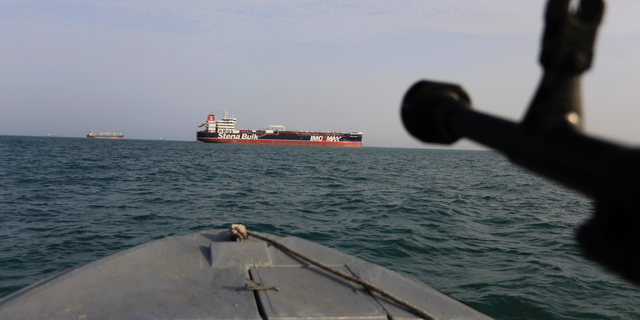 A speedboat belonging to Iran's Revolutionary Guard Corps trains a weapon toward the British-flagged oil tanker Stena Impero, which was seized in the Strait of Hormuz on July 19. (AP/Tasnim News Agency)