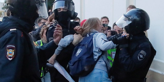 Law enforcement officers detain Muscovite Daria Sosnovskaya after a rally to demand authorities allow opposition candidates to run in the upcoming local election in Moscow, Russia Aug. 10, 2019. (REUTERS/Maxim Shemetov)