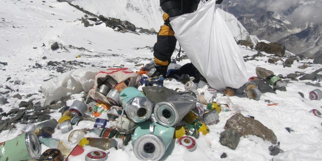 File photo - This picture taken on May 23, 2010 shows a Nepalese sherpa collecting garbage, left by climbers, at an altitude of 8,000 meters during a clean-up expedition at Mount Everest.