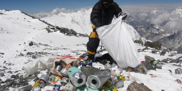 File photo - This picture taken on May 23, 2010 shows a Nepalese sherpa collecting garbage, left by climbers, at an altitude of 8,000 meters during a clean-up expedition at Mount Everest.