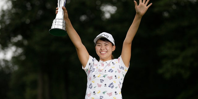 Japan's Hinako Shibuno reacts as she holds the trophy as she celebrates after winning the Women's British Open golf championship at Woburn Gold Club near near Milton Keynes, England, Sunday, Aug. 4, 2019. (AP Photo/Tim Ireland)