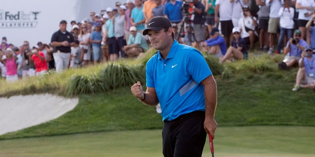 Patrick Reed pumps his fist on the 18th hole as he wins on the Northern Trust golf tournament at Liberty National Golf Course, Sunday, Aug. 11, 2019, in Jersey City, N.J. (AP Photo/Mark Lennihan)