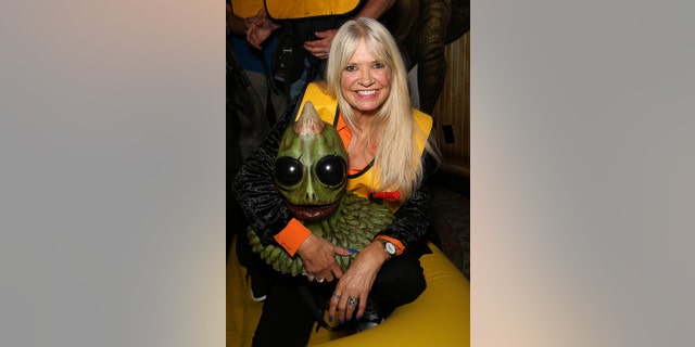 Actress Kathy Coleman poses with a Sleestak sculpture at an event in Las Vegas last month.