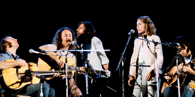 David Crosby and Joni Mitchell, surrounded by Neil Young, Graham Nash and Stephen Stills. (Photo by David Warner Ellis/Redferns)