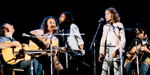 David Crosby and Joni Mitchell, surrounded by Neil Young, Graham Nash and Stephen Stills. (Photo by David Warner Ellis/Redferns)