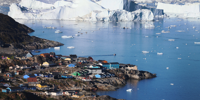 Ice floats past the village of Ilulissat in Greenland.