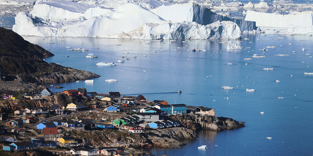 Ice floats past the village of Ilulissat in Greenland.