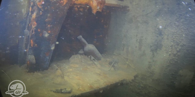 Bottles and other artifacts on a shelf in a cabin on HMS Terror’s lower deck. (Parks Canada, Underwater Archaeology Team)