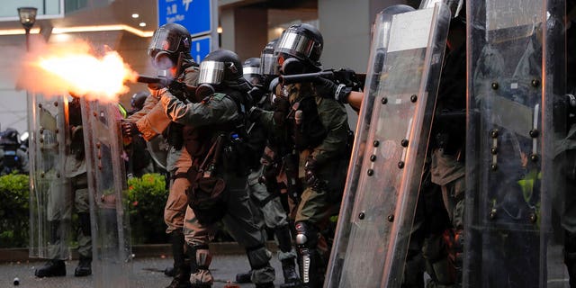 Riot police fires tear gas at protesters during a protest in Hong Kong, Sunday, Aug. 25, 2019. Police were skirmishing with protesters in Hong Kong for a second straight day on Sunday following a pro-democracy march in an outlying district. (AP Photo/Kin Cheung)