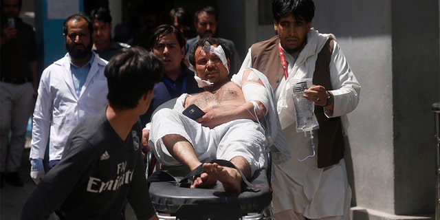 A wounded man is carried to an ambulance after an explosion in Kabul, Afghanistan. A suicide car bomber targeted the police headquarters in a minority Shiite neighborhood in western Kabul on Wednesday, setting off a huge explosion that wounded dozens of people, Afghan officials said.