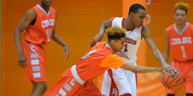 Photo shows Coolidge High's Lamar Lee-Kane, left, fouling Woodson High's Dion Crumlin during a tournament game in Washington D.C. in 2015. (Photo by John McDonnell/The Washington Post via Getty Images)