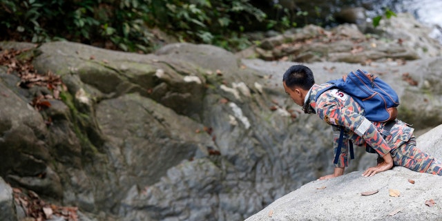 A member of a rescue team conducts a search and rescue operation for a missing British girl at a forest in Seremban, Negeri Sembilan, Malaysia, Thursday, Aug. 8, 2019.