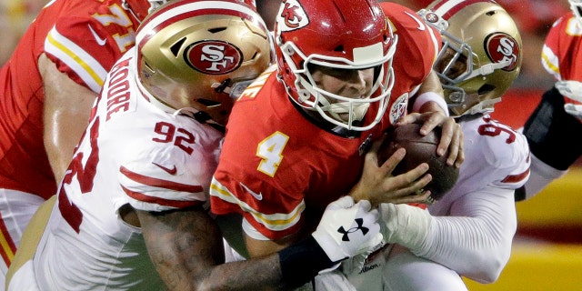 Kansas City Chiefs quarterback Chad Henne (4) is sacked by San Francisco 49ers defensive lineman Damontre Moore (92) and defensive end Arik Armstead (91) during the first half of an NFL preseason football game in Kansas City, Mo., Saturday, Aug. 24, 2019. (AP Photo/Charlie Riedel)
