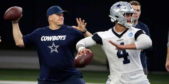 FILE - In this Wednesday, May 22, 2019 file photo, Dallas Cowboys quarterbacks coach Jon Kitna throws the ball alongside Dak Prescott (4) during NFL football practice in Frisco, Texas. Jon Kitna is back in the NFL with one of the quarterback’s former teams in the Dallas Cowboys after coaching high school football for seven years. Kitna’s return has plenty to do with his strong relationship with coach Jason Garrett. (AP Photo/Michael Ainsworth, File)