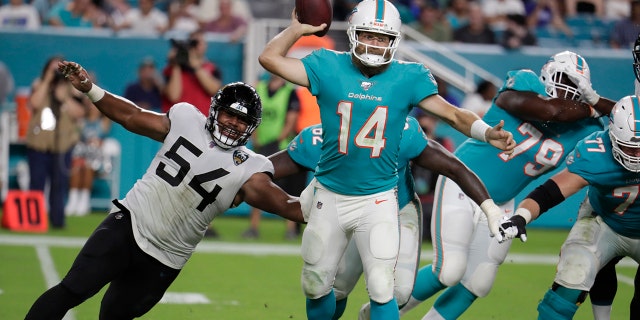 Miami Dolphins quarterback Ryan Fitzpatrick (14) prepares to pass as he is rushed by Jacksonville Jaguars defensive tackle Eli Ankou (54) during the second half of an NFL football preseason game Thursday, Aug. 22, 2019, in Miami Gardens, Fla. (AP Photo/Lynne Sladky)