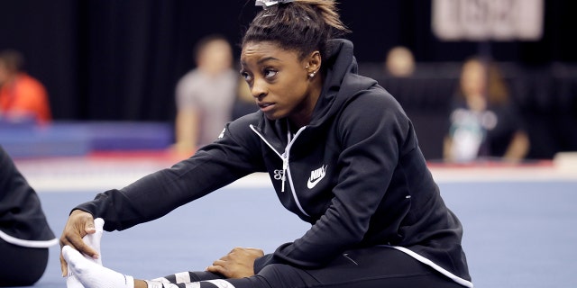 Simone Biles stretches during practice for the U.S. Gymnastics Championships Wednesday, Aug. 7, 2019, in Kansas City, Mo. (AP Photo/Charlie Riedel)