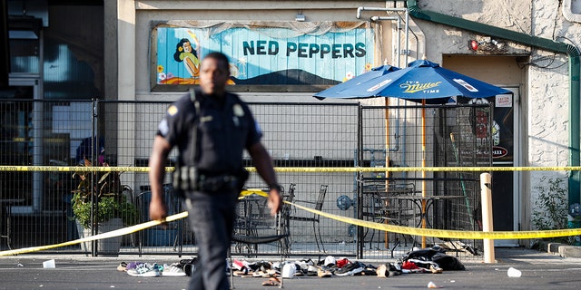 Shoes are piled outside the scene of a mass shooting including Ned Peppers bar, Sunday, Aug. 4, 2019, in Dayton, Ohio. (Associated Press)