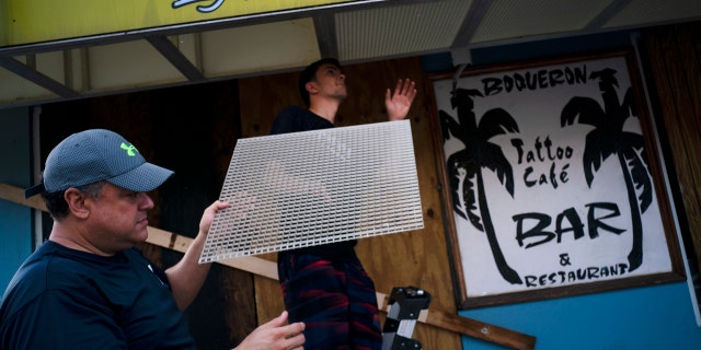 Men prep a local for the arrival of Tropical Storm Dorian in Boqueron, Puerto Rico, Tuesday, Aug. 27, 2019.