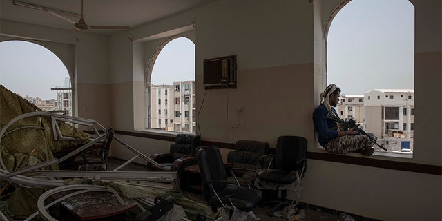 A soldier guards the site of a deadly attack inside the Sheikh Othman police station in Aden, Yemen, Thursday, Aug. 1, 2019. Yemen's rebels have fired a ballistic missile at a military parade in the southern port city of Aden as coordinated suicide bombings targeted the police station in another part of the city. The attacks killed at least 51 people and wounded dozens. 