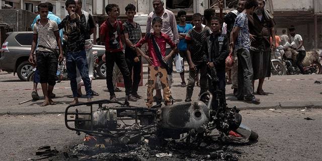 Civilians gather at the site of a deadly attack in Aden, Yemen, Thursday, Aug. 1, 2019. Yemen's rebels have fired a ballistic missile at a military parade in the southern port city of Aden as coordinated suicide bombings targeted a police station in another part of the city. The attacks killed at least 51 people and wounded dozens. (AP Photo/Nariman El-Mofty)