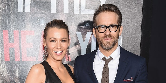 Blake Lively and Ryan Reynolds pose for cameras.