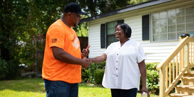 Robert Bogus III speaks with homeowner Beatrice Richard after Team Patriot members repaired her Houston, Texas home.