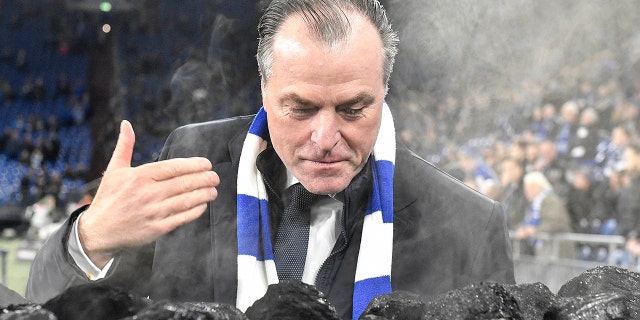FILE-In this Dec. 19, 2018 file photo Schalke boss Clemens Toennies smells steaming coal on a trolley beside the pitch prior the Bundesliga soccer match between FC Schalke 04 and Bayer Leverkusen in Gelsenkirchen, Germany. Schalke chairman Clemens Tönnies has resisted calls to resign and will instead step down for three months over comments he made last week that were widely condemned as racist. (AP Photo/Martin Meissner)