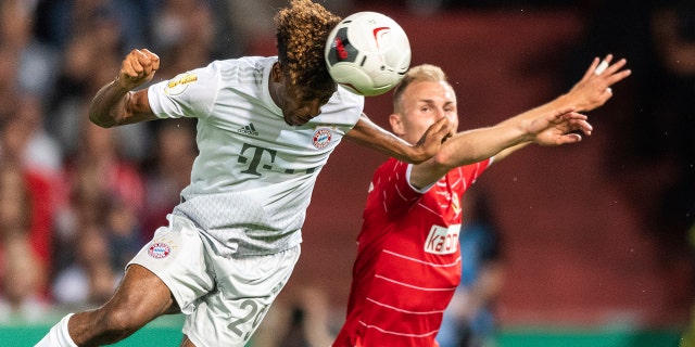 Munich's Kingsley Coman, left, and Tobias Hasse from Cottbus challenge for the ball during the German soccer cup, DFB Pokal, first Round match between FC Energie Cottbus and FC Bayern Munich in Cottbus, Germany, Monday, Aug. 12, 2019. Foto: Robert Michael/dpa via AP)