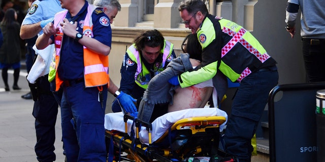 An injured woman is taken by ambulance from Hotel CBD at the corner of King and York Street in Sydney, Australia, on Tuesday, Aug. 13, 2019.