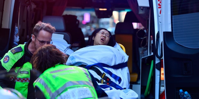 A women is taken by ambulance from Hotel CBD at the corner of King and York Street in Sydney, after a young man yelling about religion and armed with a knife attempted to stab several people.