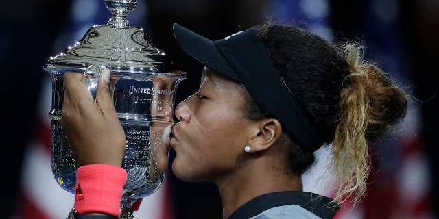 Naomi Osaka, of Japan, kisses the trophy after defeating Serena Williams, of the U.S., in the women's final of the U.S. Open tennis tournament in New York on Sept. 8, 2018. (AP Photo/Julio Cortez, File)
