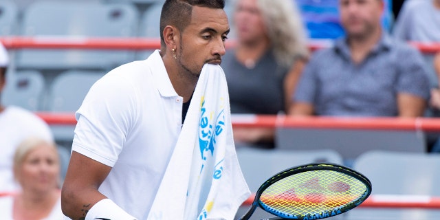 Nick Kyrgios, of Australia, walks across the court with a towel in his mouth during a break in play in his match against Kyle Edmund, of Germany, during the Rogers Cup men’s tennis tournament Tuesday, Aug. 6, 2019, in Montreal.