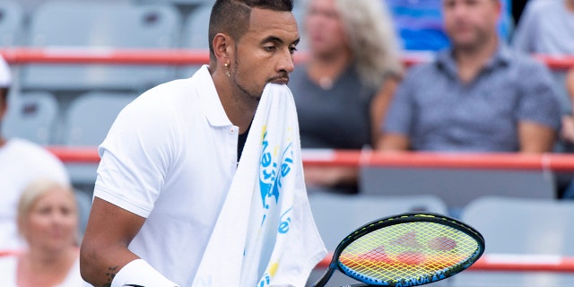 Nick Kyrgios, de Australia, camina por el campo con una toalla en la boca durante un descanso en el juego contra Kyle Edmund de Alemania, durante el torneo de tenis masculino de la Copa Rogers el martes 6 de agosto de 2019 en Montreal.