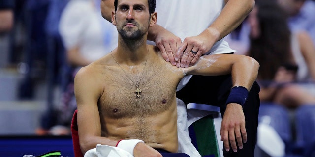 Novak Djokovic, of Serbia, receives treatment from a trainer during his match against Juan Ignacio Londero, of Argentina, during the second round of the U.S. Open tennis tournament in New York, Wednesday, Aug. 28, 2019. (AP Photo/Charles Krupa)